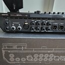 Zadávací panel černého elektronického zařízení s různými konektory. Jsou zde nápisy CONTROL, INPUTS (s označením INSTRUMENT 1 a 2, MIC), SEND, RETURN…