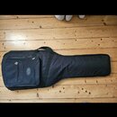 Černý softcase na hudební nástroj s ramenním popruhem a přední kapsou. Na kapse je viditelné oválné logo s nápisem Cordoba. Povrch materiálu vypadá h…