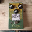 Zelený kytarový efekt s nápisy Plumes a EarthQuakerDevices®. Na horní straně jsou tři černé kontrolní knoflíky s popisky Level, Tone a Gain a přepína…