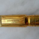 Zlatý kovový mouthpiece s černým náústníkem. Na boku je vyryté „Otto Link“ a na zadní části nápis „MADE IN USA TONE MAST... NY“. Povrch vykazuje znám…