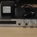 Stříbrný rackový procesor s černým šasi. Na předním panelu jsou nápisy ROCKITRON PROFESSIONAL SERIES a XPRESSION, dále text CARVING GUITAR & BASS DIG…