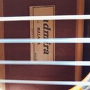 Detail vnitřku akustického nástroje s viditelným štítkem. Na štítku je černý nápis Admira a pod ním text MALAGA. Vlevo jsou menší nápisy Fabricado en…