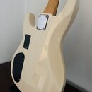Zadní strana elektrické kytary v krémové barvě s jasným lakem. Na zadní straně těla je kovový štít s nápisem "Leo Fender" a textem "CUSTOM SHOP STRAT…