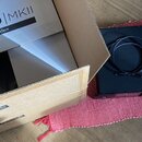Na fotografii je černý audio rozhraní v doprovodu původního kartonového boxu. Na krabici je nápis Symphony I/O | MKII a Multi-Channel Audio Interface…