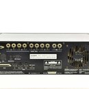 Zadní strana černého elektronického zařízení s řadou konektorů. Jsou zde nápisy SCSI Thru, Digital In a Out, Optical Out, KDS Output, Audio Outs (ozn…