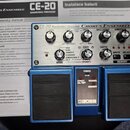 Modrý kytarový efekt s ovládacími prvky na horní straně. Na přístroji jsou nápisy CE-20 DIMENSIONAL PROCESSOR a CHORUS ENSEMBLE, v dolní části je log…