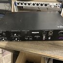 Černý rackový procesor s nápisem AVID na zadní straně. Zařízení obsahuje různé vstupy a výstupy označené jako FX LOOP (SEND, RETURN), MAIN OUTPUT (Le…