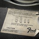 Fotografie detailně zachycuje papírovou nálepku s instrukcemi k elektronkovým trubicím. Na štítku je uveden nápis FENDER MUSICAL INSTRUMENTS, FULLERT…