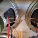 Fotografie zachycuje zadní stranu dvou reproduktorů s připojeným kabelážím. Na magnetu levého reproduktoru je vidět nápis 031417. K oběma reproduktor…