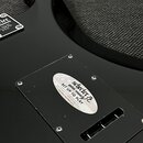 Černý lakovaný povrch zadní strany kytary s kovovou krytkou elektroniky. Na krytce je oválná nálepka s nápisy Schecter guitar research, SET UP TO PLA…