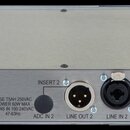 Zadní strana stříbrného rackového zařízení s kovovým šasi. Jsou zde viditelné konektory XLR, jacky a napájecí vstup s nápisem FUSE T5AH 250VAC, POWER…