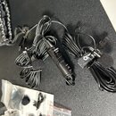 Sada černých klopových mikrofonů s dlouhými kabely a přívodním kabelem. Na jednom z mikrofonů je viditelný nápis SYNCO LIMITED a ovládací prvky. Souč…