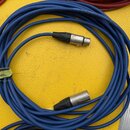 Modrý kabel s dvěma XLR konektory. Na jednom z konců je na modré izolaci zelená nálepka s nápisem „8 m.“. Na kovové části konektoru je viditelný neči…