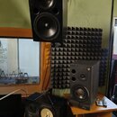Na fotografii jsou tři černé reproduktory značky YAMAHA. Horní reproduktor je umístěn na stěně, prostřední stojí na dřevěném stole a spodní je polože…