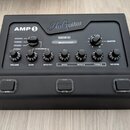Černý kytarový zesilovač s nápisy AMP 1 a BluGuitar. Na horním panelu se nachází přepínač s označením MODERN, CLASSIC, VINTAGE a CLEAN, kontrolky NAN…