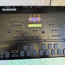Černý sampler Ensoniq ASR-X Advanced Sampler/Resampler. Zařízení má LCD displej, několik tlačítek a ovládacích prvků s nápisy jako Disk / Global, Eff…