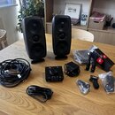 Sada černých studiových monitorů s dvěma reproduktory v každém. V doprovodu je černý zesilovač s nápisem airblue, napájecí adaptér a dva bezdrátové m…
