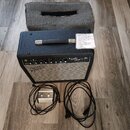 Černý kytarový kombo zesilovač s bílým mřížkovým potahem reproduktoru. Na přední straně je nápis Fender a vpravo označení modelu Super Champ 32. K ze…