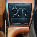 Detail předzesilovače zabudovaného v těle akustické kytary s dřevěným povrchem. Černý ovládací panel nese nápis TP-4T a obsahuje knoflík Gain s označ…