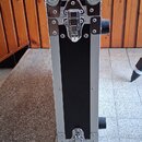 Černý transportní kufr s hliníkovými hranami a chromovaným kováním. Na čelní straně jsou dvě kovové zámky a čtyři kulaté chromované rohy. Na pravém b…