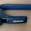 Černý kovový ladicí klíč v podobě svorky. Na boku je bílým nápisem uvedena značka D'Addario a na knurlovaném knoflíku je bílé logo. Povrch nástroje v…