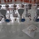 Sada šesti chromovaných ladicích kolínek umístěných v průhledném plastovém držáku. Kolínka mají kovové knoflíky a modré plastové vložky u základny. V…