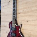 Elektrická kytara s červeným plamenovitým povrchem těla a bílým lemováním. Na hlavě je viditelné logo Epiphone. Nástroj má dva humbuckery, čtyři ovlá…