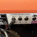 Zadní panel kytarového komba s oranžovým potahem. Je zde nápis EXTERNAL SPEAKER OUTPUTS a tři výstupní konektory označené 16Ω, 8Ω a 8Ω, z nichž v prv…
