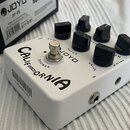 Bílý kytarový efekt s nápisem CALIFORNIA SOUND a logem JOYO. Na horní straně jsou čtyři černé oválné ovládací knoflíky s popisky VOLUME, DRIVE a GAIN…