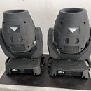 Dvě černé pohyblivé světelné hlavy umístěné na transportním kufru. Na spodní části obou zařízení je viditelné bílé logo CHAUVET DJ. Povrch plastového…