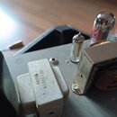 Fotografie zachicuje vnitřní komponenty elektronického zařízení. V popředí je kovový blok s nápisy IF-3021H a 066529. Vedle něj jsou vidět dvě elektr…