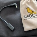Černý kabel s konektory na obou koncích, položený na černé textilní tašce. Vedle kabelu je béžový látkový vak s žlutým obrázkem ptáka a nápisem BIRD…