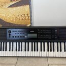 Černý digitální klavír značky YAMAHA. Nástroj má ovládací panel s displejem a množstvím tlačítek, z nichž některá jsou označena nápisy jako STYLE neb…