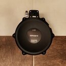 Černý elektronický bicí pad s nápisem PDX-100 DUAL TRIGGER PAD a logem Roland. Dole je uveden text Roland Corporation s adresou v Japonsku a značkou…
