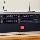 Hliníkový přepravní kufr obsahuje dva černé bezdrátové přijímače značky Letone, model free solo Twin DR 590 MHz. Každý přijímač má digitální displej…