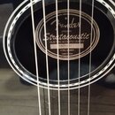 Detail rozetky černé akustické kytary. Uvnitř je štítek s nápisy Fender, ORIGINAL Stratacoustic™, ELECTRIC ACOUSTIC GUITAR a sériovým číslem 50208181…
