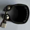 Černý kožený nástavce na hmatník s kovovým šroubem a dvěma kulatými kovovými zakončeními. Vnitřní strana je vyložena černým materiálem s ozubeným pro…