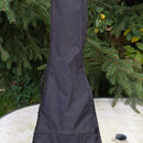 Černý textilní pouzdro (gig bag) na kytaru. Pouzdro je umístěno svisle na bílém stole v zahradě. Na povrchu nejsou viditelné žádné značky ani nápisy.