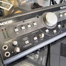 Šedý monitorovací kontrolér značky MACKIE s nápisem BIG KNOB STUDIO COMMAND SYSTEM. Zařízení obsahuje velký centrální knofík VOLUME, sekci INPUT SOUR…