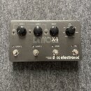 Šedý kytarový pedál s nápisem DITTO X4 LOOPER a logem tc electronic. Zařízení má čtyři stoupací spínače označené jako LOOP 1, LOOP 2, STOP a FX. Na h…