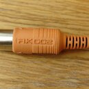 Detail konektoru kabelu s kovovým hrotem a oranžovou gumovou krytkou. Na krytce je vyražen nápis RK002. Kabel má černou barvu a je připojen k oranžov…