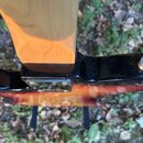 Detail spoje krku a těla elektrické kytary. Krk je vyroben ze světlého dřeva, tělo má černý lakovaný povrch a spodní část je provedena v červeně žlut…