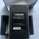 Fotografie zachycuje spodní stranu černého kytarového efektu značky BOSS v kovovém šasi. Na spodní štítku je uveden nápis CAN ICES-003(B)/NMB-003(B),…