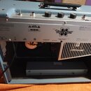 Zadní strana modrého kytarového komba s otevřeným šasi. Na kovovém zadním panelu je viditelné logo Vaporizer v doprovodu grafického symbolu atomu a n…