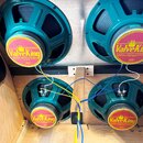 Čtyři reproduktory s tmavě zeleným kovovým rámem a žlutými štítky s nápisem ValveKing CLASSIC™ VOICED SPEAKER. Na štítcích je dále uveden text 16 Ohm…