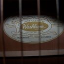 Detail vnitřní štítku akustické kytary. Na štítku je uveden nápis Washburn GUITARS, CHICAGO ORIGINAL OVER A CENTURY OF EXCELLENCE EST. 1883 a Made in…