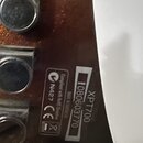 Detail zadní strany hnědého nástroje s kovovými součástmi. Na povrchu je nalepená štítková nálepka s nápisy „Compliant with RoHS Directive“, „N427“,…