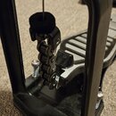 Detailní záběr na černý kovový mechanismus bicího pedálu. Na horní části je viditelný nápis „logwerk“. Vnitřní část obsahuje řetězový pohon a šlapák…