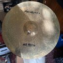 Kovový činel s viditelným klepaním povrchu. Na činely jsou nápisy AGEAN Hand Crafted Turkish Cymbal a ROCK MASTER Full Hammered. Povrch vykazuje drob…
