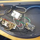 Fotografie zachycuje vnitřek elektronického prostoru v nástroji. Jsou zde vidět zapojené součástky, včetně potenciometru a spínače s nápisem ASUN 92,…